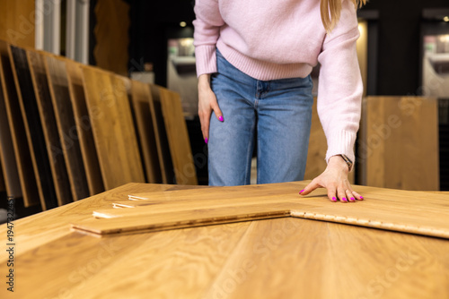 woman choosing parquet design in flooring shop