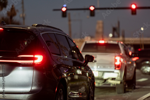 Εκτύπωση καμβά Rear view of USA evening traffic stopped at a red light, with a dark SUV, white