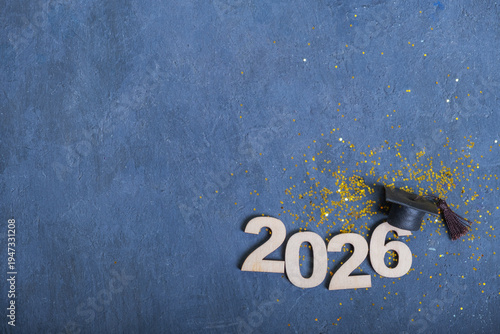 Number 2026 with graduation cap on dark blue background with tinsel