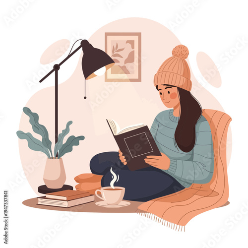 Young woman reading a book in a cozy room with coffee and lamp