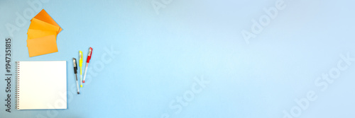 vibrant idea station, colorful memo pads with writing tools on pale blue surface for ideas, brightly colored sticky notes and pens arranged on calming blue background for idea development