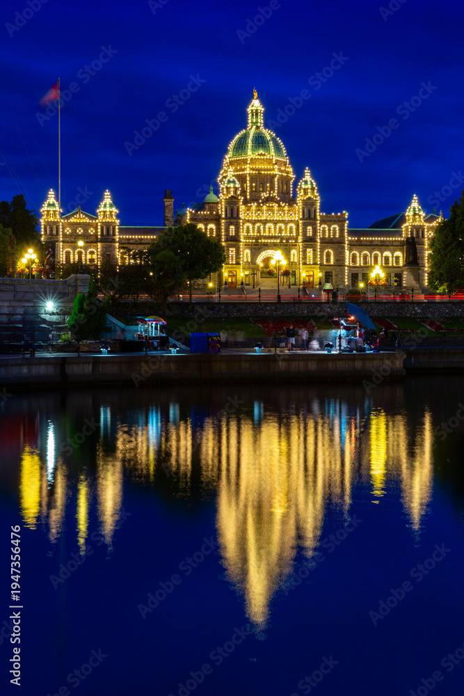 Fototapeta premium Victoria Parliament Building Inner Harbour Reflection. Victoria's Inner Harbor and marina in downtown Victoria. The historic Legislative Building at night looks over the harbor. British Columbia. 
