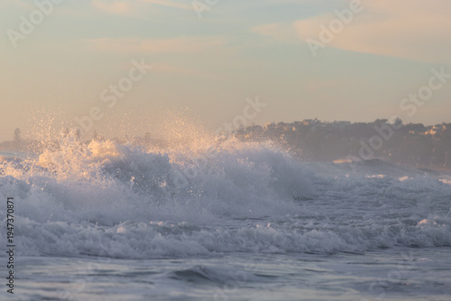 Breaking wave on the beach shore in the morning.