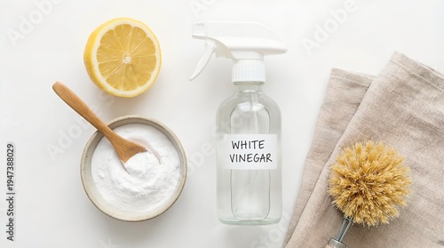 Eco-Friendly Cleaning: Lemon, Baking Soda, Vinegar and Brush. A minimalist shot of eco-friendly cleaning supplies, with lemon, baking soda, white vinegar, brush and cloth.