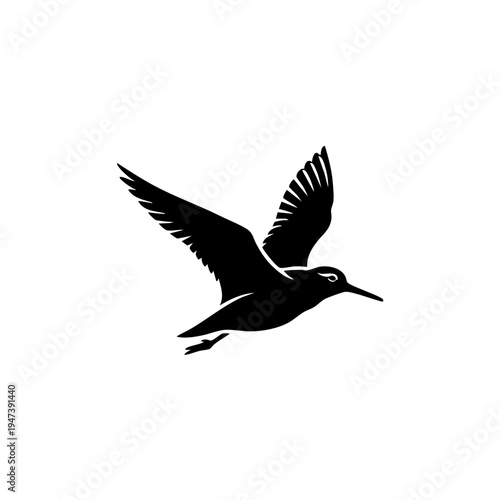 Graceful black silhouette of a bird in mid-flight with outstretched wings