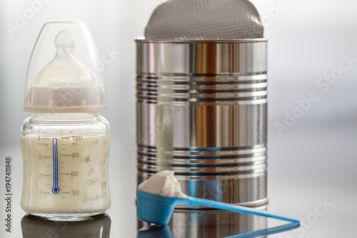 Preparing baby formula, infant formula, baby milk bottle, scoop of milk powder, grey background