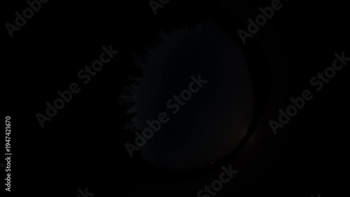 Night sky timelapse in fisheye lens view, 360 degree circular perspective of moving clouds and stars over dark forest at dusk, celestial abstract background