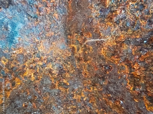 Rusted metal surface with a coarse, flaky texture. 