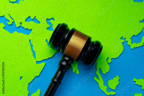 Tableau sur toile Top down view of a judge's gavel on a paper world map cutout