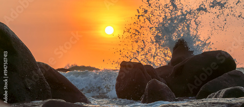 Wallpaper Mural Sunrise landscape at tropical beach. The warm golden light of illuminating the sea spray creates a striking silhouette of the rocks against the glowing sky Torontodigital.ca