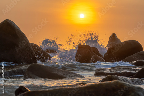 Wallpaper Mural Sunrise landscape at tropical beach. The warm golden light of illuminating the sea spray creates a striking silhouette of the rocks against the glowing sky Torontodigital.ca