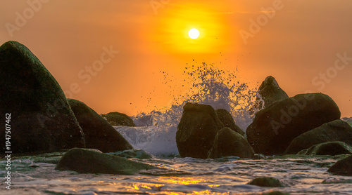 Wallpaper Mural Sunrise landscape at tropical beach. The warm golden light of illuminating the sea spray creates a striking silhouette of the rocks against the glowing sky Torontodigital.ca