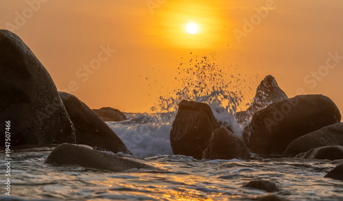 Wallpaper Mural Sunrise landscape at tropical beach. The warm golden light of illuminating the sea spray creates a striking silhouette of the rocks against the glowing sky Torontodigital.ca
