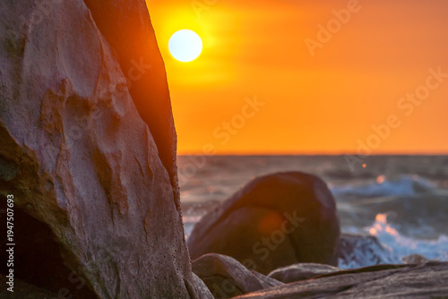 Wallpaper Mural Sunrise landscape at tropical beach. The warm golden light of illuminating the sea spray creates a striking silhouette of the rocks against the glowing sky Torontodigital.ca