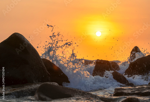 Wallpaper Mural Sunrise landscape at tropical beach. The warm golden light of illuminating the sea spray creates a striking silhouette of the rocks against the glowing sky Torontodigital.ca