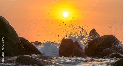 Wallpaper Mural Sunrise landscape at tropical beach. The warm golden light of illuminating the sea spray creates a striking silhouette of the rocks against the glowing sky Torontodigital.ca