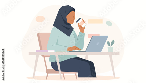 Woman wearing hijab working on laptop.