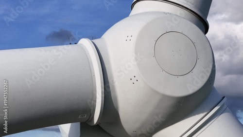 low high res wind turbine rounded hub housing access panel sensor mast blade connections against bright cumulus clouds clean electricity engineering reveals angle view structure 