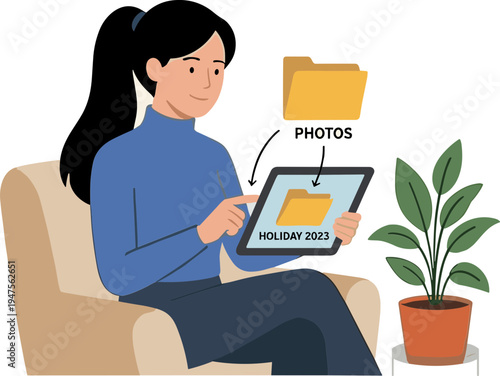 Woman sitting on sofa uses tablet to view holiday photos with plant nearby
