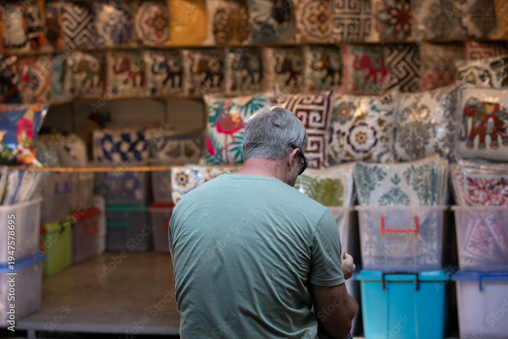 Obraz premium Senior man sitting resting in market, casual urban walking Thailand, human presence in urban environment, public life concept, rear view, Chatuchak