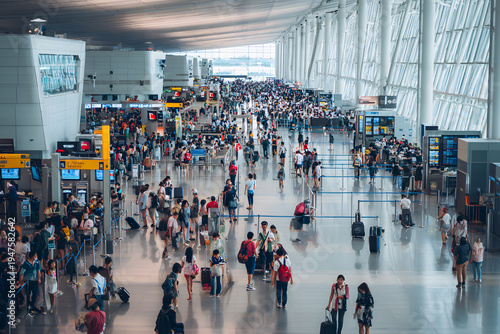 Wide-angle view of a bustling, modern airport terminal filled with diverse travelers and organized check-in counters. Global travel and infrastructure concept