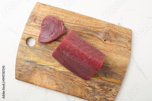 Quadro su tela Raw red tuna loin on a wooden cutting board on white