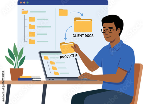 A man sitting at a desk holds a file while working on a laptop in an office.