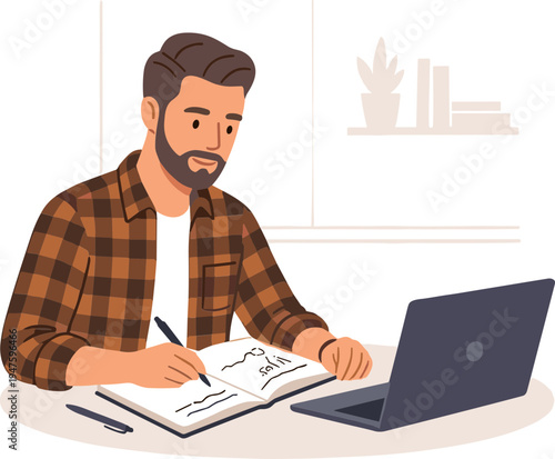 Man sitting at desk writing in notebook next to laptop