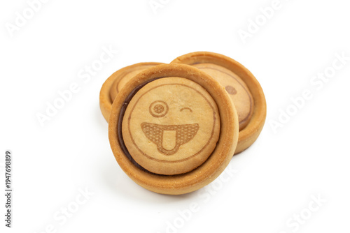 Stack of round cookies with funny winking face emoticon and chocolate cream filling, isolated on white background.