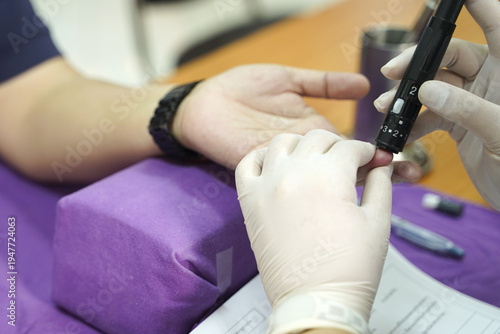 Close-up of a digital glucometer showing a normal blood sugar reading of 107 mg/dL after a successful finger prick test in a clinical setting.