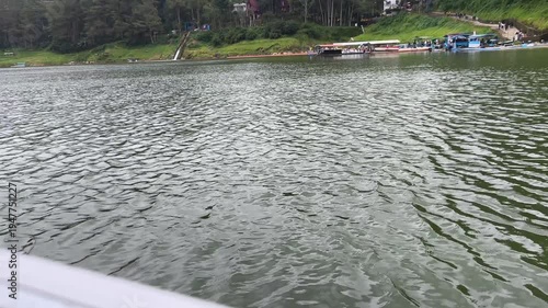 Close up of rippling lake water surface taken from a moving boat. Dynamic water texture with small waves and reflections on a cloudy day. Deep water surface movement for background or transition foota