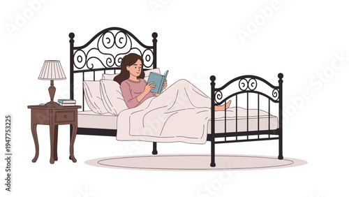 Young woman comfortably lying in bed at night while reading an interesting book by the light of a bedside lamp in a cozy bedroom.
