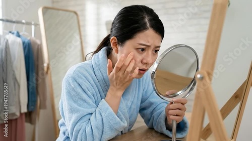 Wallpaper Mural Concerned woman examining her face in a mirror, touching skin, worried about wrinkles and aging Torontodigital.ca