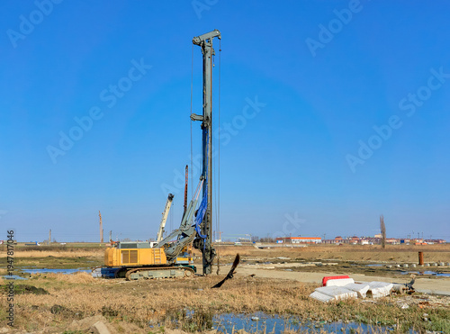 Obraz na plátně Industrial rotary drilling rig in open field under clear blue sky
