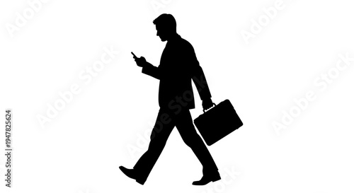 Silhouette of a businessman walking with a briefcase and looking at his smartphone.
