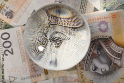 Tableau sur toile Magnifying glass lying on Polish 200 PLN banknotes, high magnification macro pho