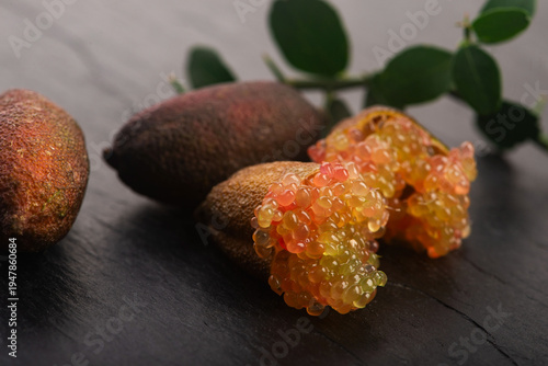 Finger Lime Cut Open with Citrus Caviar on Black Stone Base
