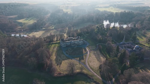 Cinematic drone shot of the abandoned Old Penicuik House: Majestic ruins of a Scottish manor house surrounded by autumn fields and forest
