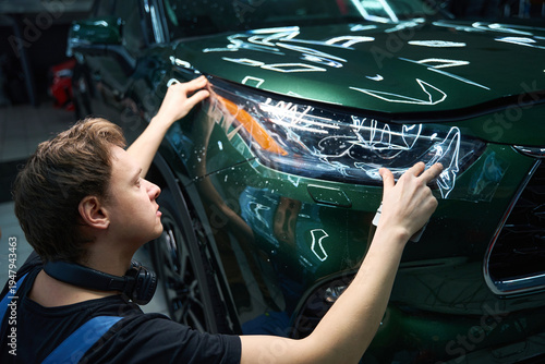 Experienced professional is applying protection film to auto headlight