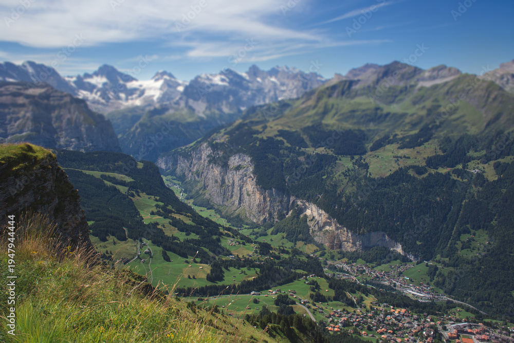 Fototapeta premium Panoramic view of the Lauterbrunnen valley with steep cliffs and Alpine peaks