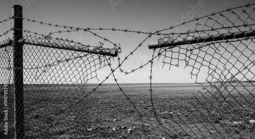 Broken Barbed Wire Chain Link Fence In Rural Landscape