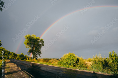 Photos Double rainbow spanning rural road after rain