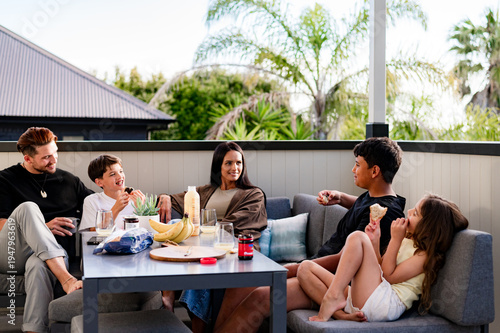 Family with mixed ethnicity having a snack on the balcony