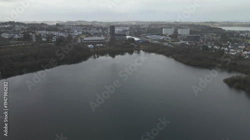 Wallpaper Mural Aerial drone footage showing a lake under moody weather conditions. The scene features calm water, subdued lighting, and overcast skies, presenting a quiet natural landscape with minimal movement and  Torontodigital.ca