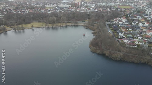 Wallpaper Mural Aerial drone footage showing a lake under moody weather conditions. The scene features calm water, subdued lighting, and overcast skies, presenting a quiet natural landscape with minimal movement and  Torontodigital.ca