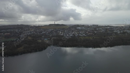 Wallpaper Mural Aerial drone footage showing a lake under moody weather conditions. The scene features calm water, subdued lighting, and overcast skies, presenting a quiet natural landscape with minimal movement and  Torontodigital.ca