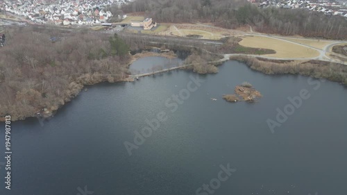 Wallpaper Mural Aerial drone footage showing a lake under moody weather conditions. The scene features calm water, subdued lighting, and overcast skies, presenting a quiet natural landscape with minimal movement and  Torontodigital.ca