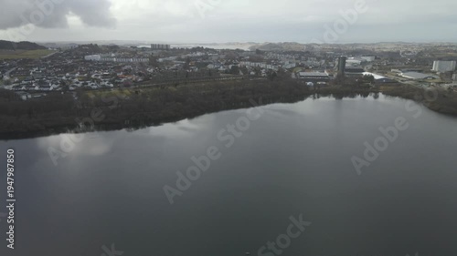 Wallpaper Mural Aerial drone footage showing a lake under moody weather conditions. The scene features calm water, subdued lighting, and overcast skies, presenting a quiet natural landscape with minimal movement and  Torontodigital.ca