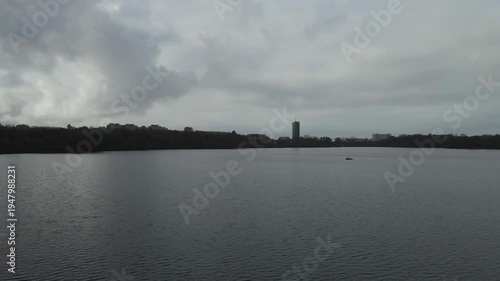 Wallpaper Mural Aerial drone footage showing a lake under moody weather conditions. The scene features calm water, subdued lighting, and overcast skies, presenting a quiet natural landscape with minimal movement and  Torontodigital.ca