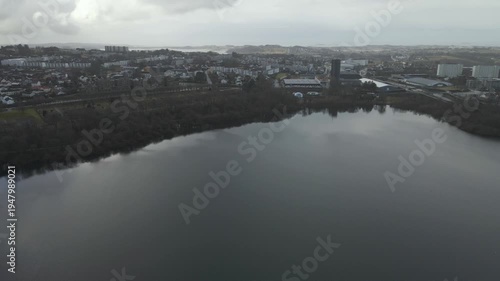 Wallpaper Mural Aerial drone footage showing a lake under moody weather conditions. The scene features calm water, subdued lighting, and overcast skies, presenting a quiet natural landscape with minimal movement and  Torontodigital.ca